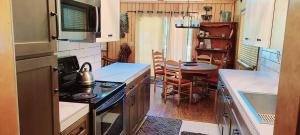 a small kitchen with a stove and a table at Lakeview Lodge, bookable boat slip! in Bass Lake