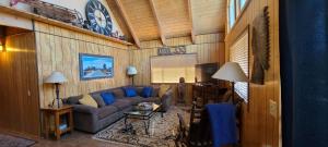 a living room with a couch and a clock on the wall at Lakeview Lodge, bookable boat slip! in Bass Lake