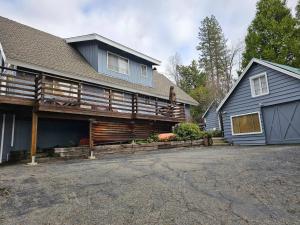 a house with a porch and a garage at Lakeview Lodge, bookable boat slip! in Bass Lake