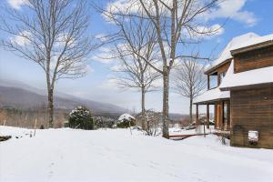 une maison dans la neige avec des arbres et des montagnes dans l'établissement Valley View, à Stowe