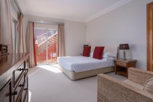 een slaapkamer met een bed en een groot raam bij Palheiro Village Resort in Funchal +36 foto's