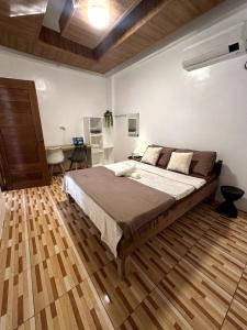 ein Schlafzimmer mit einem großen Bett und einem Schreibtisch in der Unterkunft Bayay Tayuha 2BR island work home WiFi with UPS in General Luna
