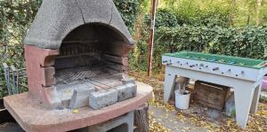 a outdoor brick oven with a pool table on it at Tripplezimmer mit Garten, Kicker und Grill in Berlin