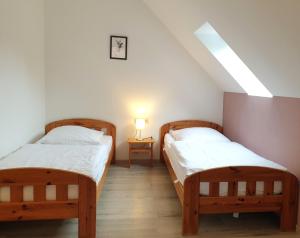 2 Einzelbetten in einem Zimmer mit einer Lampe in der Unterkunft Natur Ferienpark 29 - Typ C in Nieheim