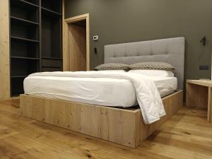 a large bed with a wooden frame in a bedroom at Casa Lucia in Valdidentro