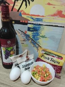 une bouteille de vin, des œufs et un bol de fruits dans l'établissement The Viceroy Tower Staycation at McKinley Hills Taguig, à Manille 1 autre photo