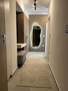 a hallway with a sink and a mirror on the wall at UrbanNest Aerodrom in Skopje