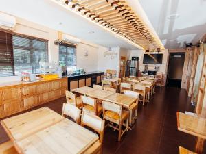 un restaurante con mesas y sillas de madera y una cocina en Semerah Garden Hotel, en Pontian Kecil