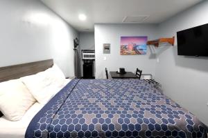 a bedroom with a bed and a tv on the wall at Hillsboro Inn & Suites in Hillsboro