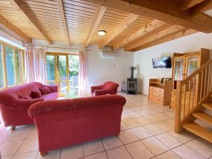ein Wohnzimmer mit zwei roten Sofas und einem TV in der Unterkunft Natur Ferienpark 27 - Ferienhaus Typ A in Nieheim
