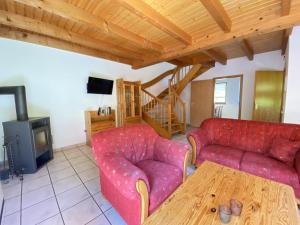 ein Wohnzimmer mit zwei roten Sofas und einem Holztisch in der Unterkunft Natur Ferienpark 27 - Ferienhaus Typ A in Nieheim