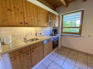 eine Küche mit Holzschränken und Spüle und einem Fenster in der Unterkunft Natur Ferienpark 26 - Typ A in Nieheim