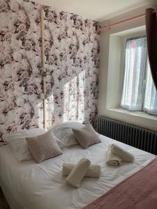 a white bed with two pillows on top of it at Auberge Les Bastides 