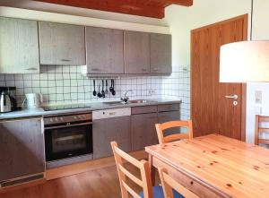 a kitchen with wooden cabinets and a table and a dining room at Natur Ferienpark 8 - Typ A in Nieheim