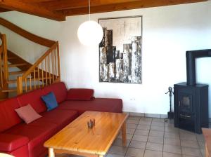 ein Wohnzimmer mit einer roten Couch und einem Holztisch in der Unterkunft Natur Ferienpark 30 - Typ C in Nieheim