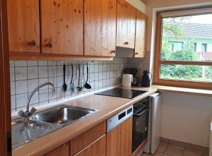 eine Küche mit Holzschränken und Spüle und einem Fenster in der Unterkunft Natur Ferienpark 30 - Typ C in Nieheim