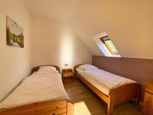 two beds in a small room with a window at Haus 23 Natur Ferienpark - Gemütlicher Urlaubsort für entspannte Tage im Grünen und in der Nähe von den Externsteinen in Nieheim