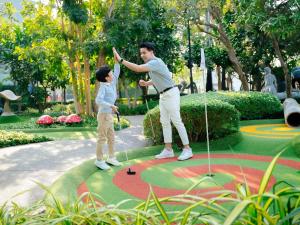 een man en een kind die een spelletje golf spelen bij SO/ Sofitel Hua Hin in Cha Am