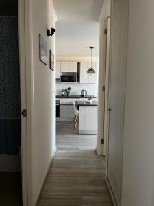a hallway leading to a kitchen with white cabinets at Departamento nuevo a 5 min de la playa 2D 2B in La Serena