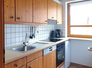 a kitchen with wooden cabinets and a sink at Natur Ferienpark 10 - Typ C in Nieheim