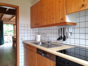 a kitchen with wooden cabinets and a sink at Natur Ferienpark 10 - Typ C in Nieheim