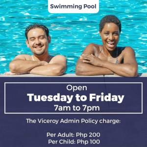 un homme et une femme dans l'eau d'une piscine dans l'établissement The Viceroy Tower Staycation at McKinley Hills Taguig, à Manille