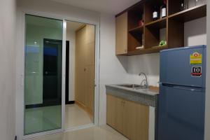 uma cozinha com um frigorífico e um lavatório em Wisdom Residence em Hat Yai