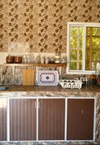 a kitchen with a counter top and a window at Al Hudu Mountain House - Jebel Shams in Al Ḩayl +40 photos