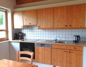 a kitchen with wooden cabinets and a sink and a table at Natur Ferienpark 25 - Typ A in Nieheim