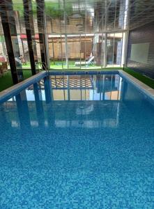 a large swimming pool with blue tiles in a building at Marina Privet chalet for rent in Al Jafr