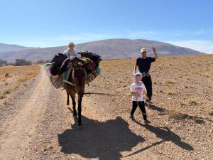 un groupe de personnes et une personne à cheval sur un chemin de terre dans l'établissement Auberge Tafouyt, à Tamtetoucht