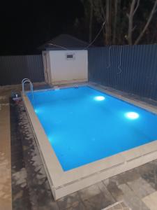 a swimming pool lit up at night at The Mountain A-Frame Qusar in Yuxarı Lǝgǝr