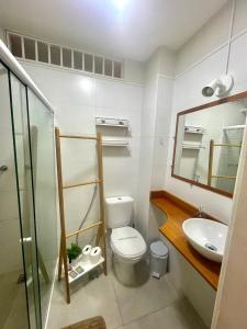 a bathroom with a toilet and a sink and a mirror at Loft espaçoso a 300m da praia in Rio de Janeiro