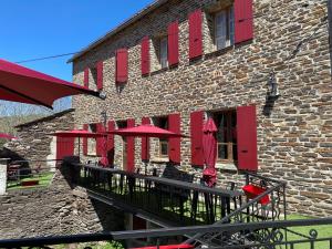 a brick building with red shutters and tables and chairs at Auberge Les Bastides  +7 photos