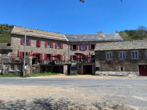 an old stone building with red doors and windows at Auberge Les Bastides 