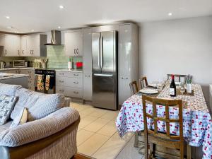 a kitchen with a table with a couch and a refrigerator at Barn Owl Cottage - Uk48510 in Kirk Hammerton