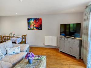 a living room with a couch and a flat screen tv at Barn Owl Cottage - Uk48510 in Kirk Hammerton +9 photos