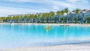 a resort on the beach with people in a boat in the water at Paradise Apt in Punta Cana in Punta Cana