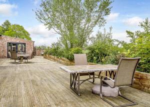 a patio with a table and chairs on a wooden deck at Ladera Retreat Lodges in Eaton