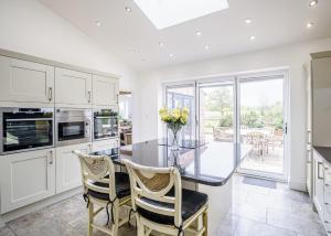a kitchen with a glass table and chairs at Ladera Retreat Lodges in Eaton