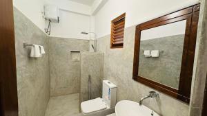 a bathroom with a sink and a toilet and a mirror at Royal Sea Wind in Matara