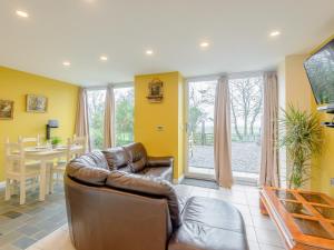 a living room with a leather couch and a table at Dutch Barn Two - Uk12873 in Brynkir