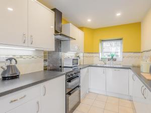 a kitchen with white appliances and yellow walls at Dutch Barn Two - Uk12873 in Brynkir