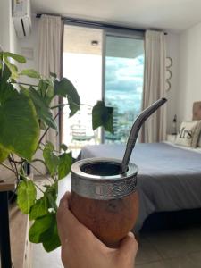 een persoon die een beker met een drankje in zijn hand houdt bij Rosario SJ Loft in Rosario