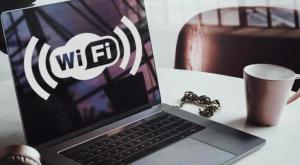 a laptop computer sitting on top of a table with a cup at UIM Mediterraneo Pablo Iglesias Wifi in Puerto de Sagunto