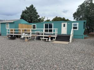 una pequeña casa azul en un lote de grava en Top of The Hill 3rd Street, en Camp Verde