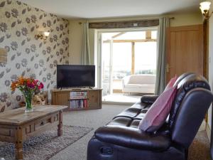 a living room with a leather chair and a television at Upper Close - Uk10873 in Evenjobb