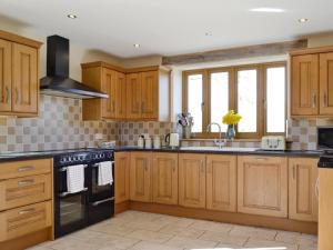 a kitchen with wooden cabinets and a stove top oven at Upper Close - Uk10873 in Evenjobb +16 photos