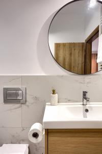 ein Badezimmer mit Waschbecken und Spiegel in der Unterkunft Sika Opulent Grand Apartment in Arad + 29 Fotos