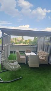 a patio with a hammock and chairs on a balcony at Vila in Chişinău